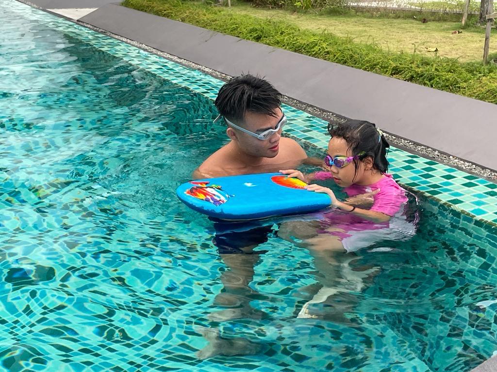 One-on-one swimming coach teaching a child at home pool in Johor Bahru